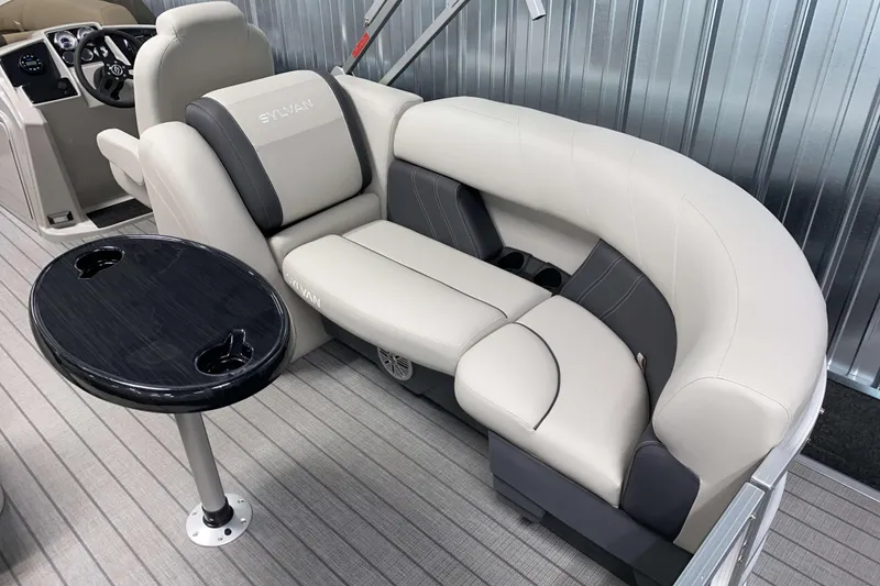 Slide: The Image of 2026 Sylvan Mirage 8522 LZ boat interior with plush seating and a sleek table. - 3