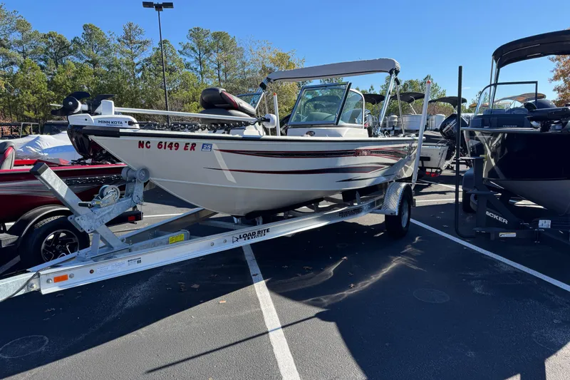 The Image of 2020 Ranger VS1682 WT boat on trailer in parking lot, surrounded by trees. - 1