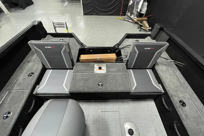 Slide: The Image of 2026 Alumacraft Competitor 175X Sport boat interior with gray seating and storage compartments. - 12