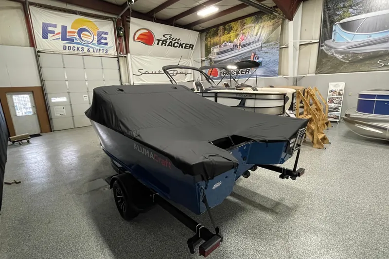 Slide: The Image of 2026 Alumacraft Competitor 175X Sport boat covered in showroom. - 19