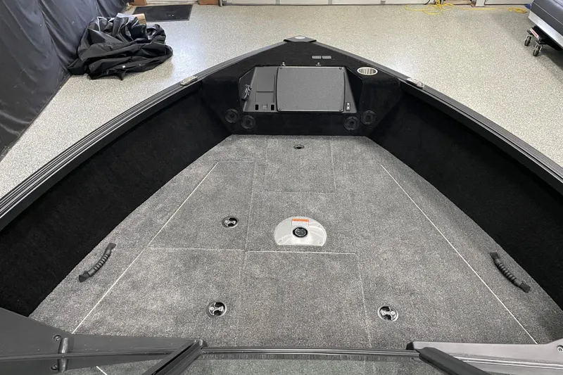 Slide: The Image of 2026 Alumacraft Competitor 175X Sport boat interior with carpeted deck and storage compartments. - 5