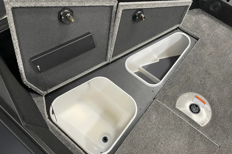 Slide: The Image of 2026 Alumacraft Competitor 175X Sport boat storage compartments with carpeted lids and white interior. - 8