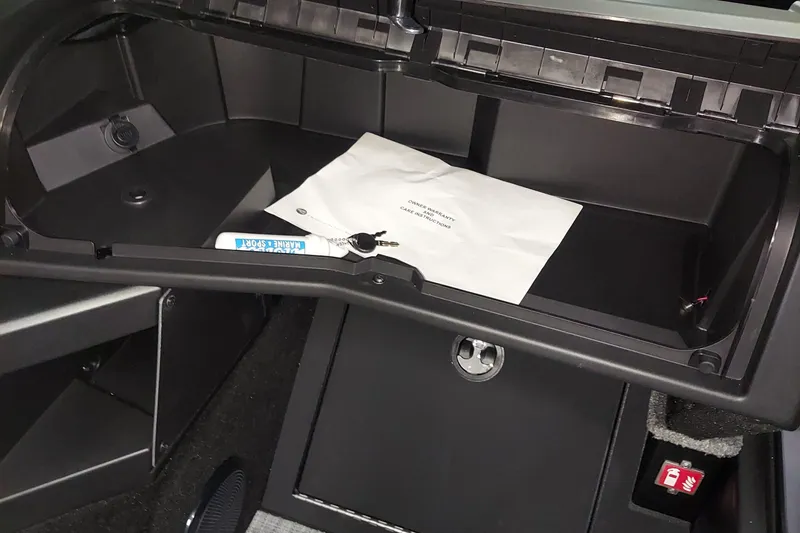 Slide: The Image of 2026 Alumacraft Competitor 175X Sport glove compartment with warranty documents inside. - 10