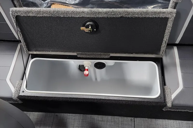 Slide: The Image of 2026 Alumacraft Competitor 175X Sport livewell compartment with open lid and drainage system. - 7