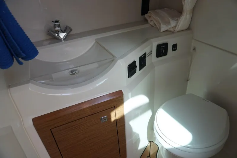 Slide: The Image of 2015 Cruisers Yachts 328 BR bathroom with sink, toilet, and wooden cabinet. - 8