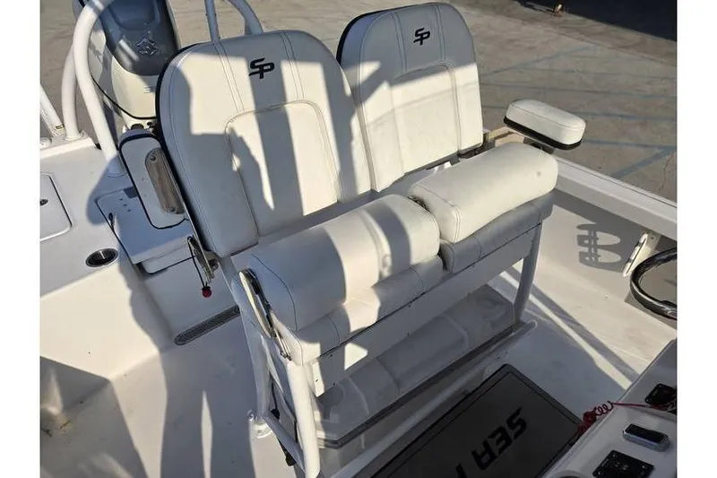 Slide: The Image of 2021 Sea Pro 248 Bay boat interior with dual white seats and console. - 10