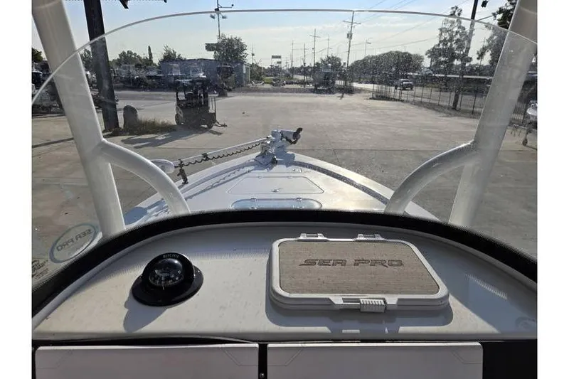 Slide: The Image of 2021 Sea Pro 248 Bay boat dashboard view with windshield and outdoor setting. - 15