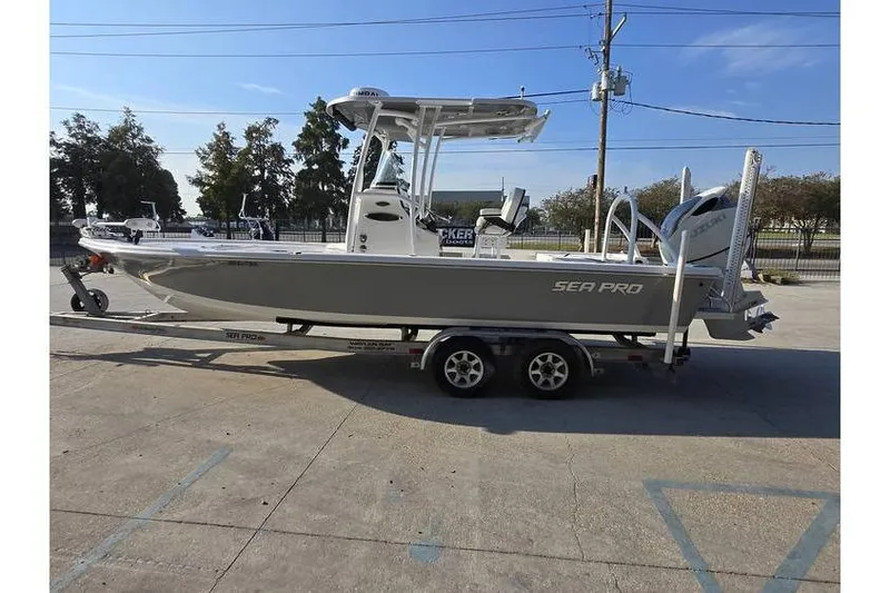 Slide: The Image of 2021 Sea Pro 248 Bay boat on trailer, parked outdoors under clear sky. - 4