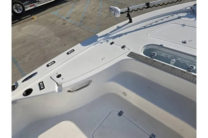 Slide: The Image of 2021 Sea Pro 248 Bay boat deck with storage compartments and fishing rod holders. - 8