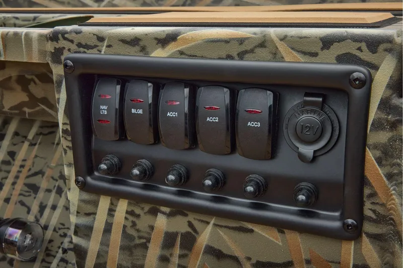 Slide: The Image of Control panel of 2026 Tracker Grizzly 1756 T Marsh boat with switches and 12V outlet. - 13