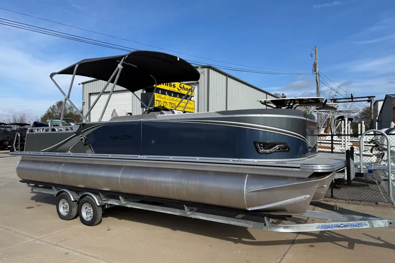 The Image of 2026 Avalon LSZ Versatile Rear Lounger pontoon boat on trailer, outdoor display. - 0
