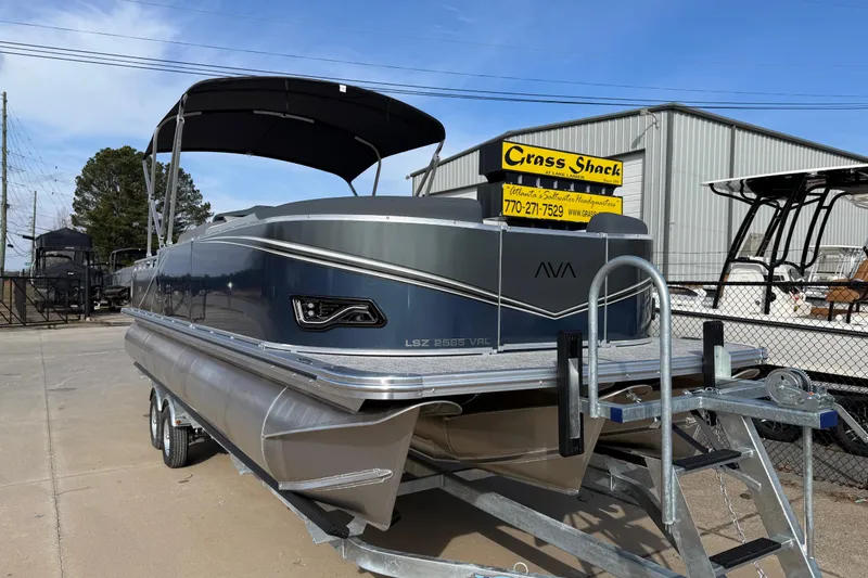 Slide: The Image of 2026 Avalon LSZ Versatile Rear Lounger pontoon boat on trailer at dealership. - 1