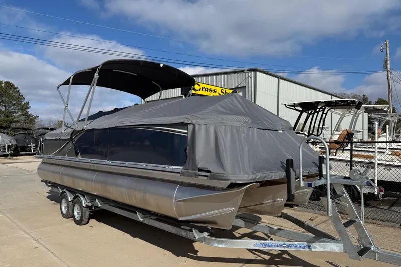 Slide: The Image of 2026 Avalon LSZ Versatile Rear Lounger pontoon boat on trailer, covered and parked outdoors. - 4