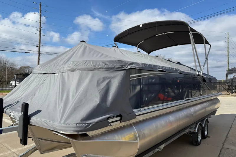 Slide: The Image of 2026 Avalon LSZ Versatile Rear Lounger pontoon boat with cover, parked on a trailer. - 6