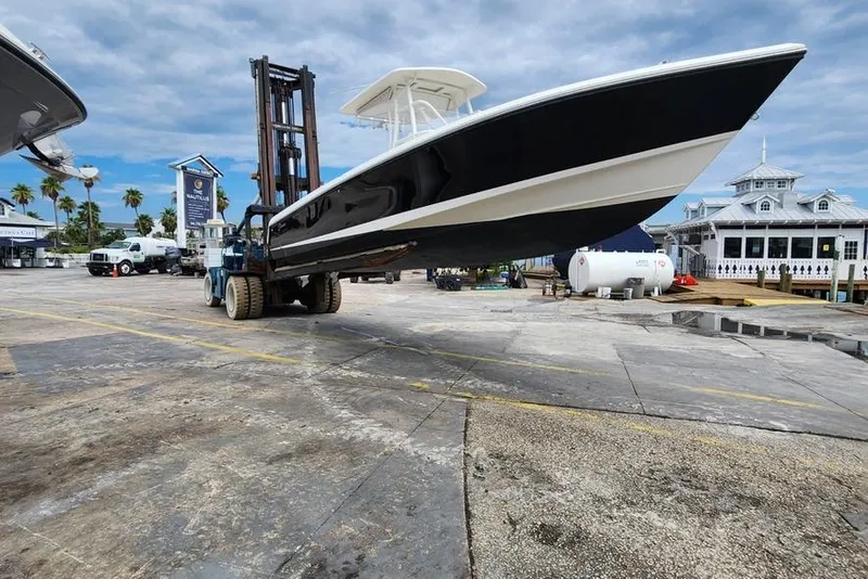 Slide: The Image of 2017 Stamas 308 Predator boat lifted by forklift at marina, clear sky background. - 11