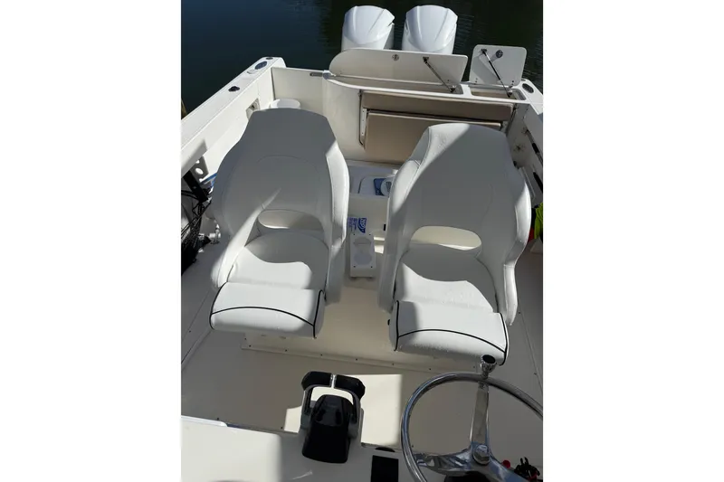 Slide: The Image of 2017 Stamas 308 Predator boat cockpit with dual white seats and steering wheel. - 21