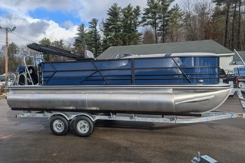 Slide: The Image of 2025 Berkshire 22CL CTS 3.0 pontoon boat on trailer, parked outdoors. - 5