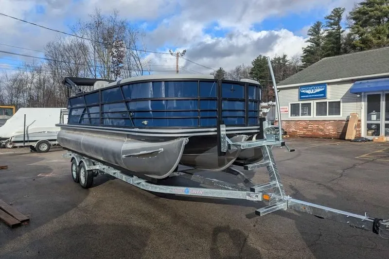 Slide: The Image of 2025 Berkshire 22CL CTS 3.0 pontoon boat on trailer, parked outdoors. - 6