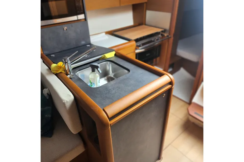 Slide: The Image of Compact kitchen area in 2023 Jeanneau Sun Odyssey 349 sailboat, featuring a sink and stove. - 18