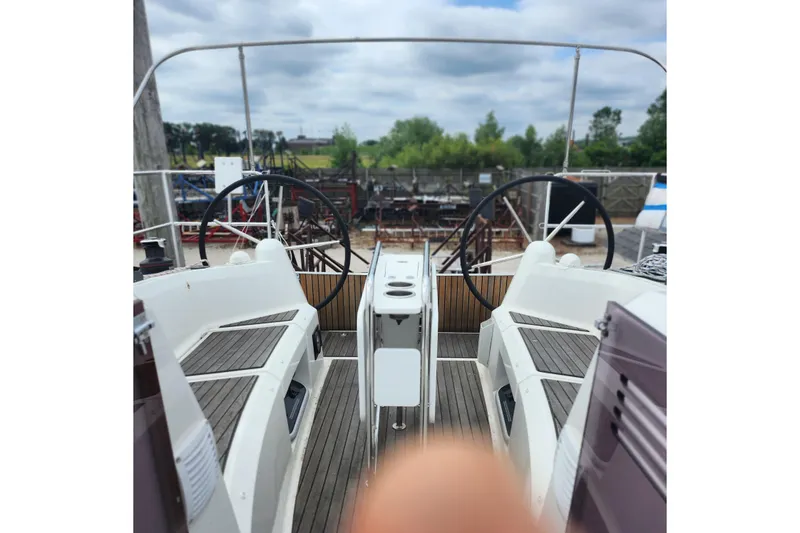 Slide: The Image of 2023 Jeanneau Sun Odyssey 349 cockpit with dual steering wheels and wooden deck. - 20
