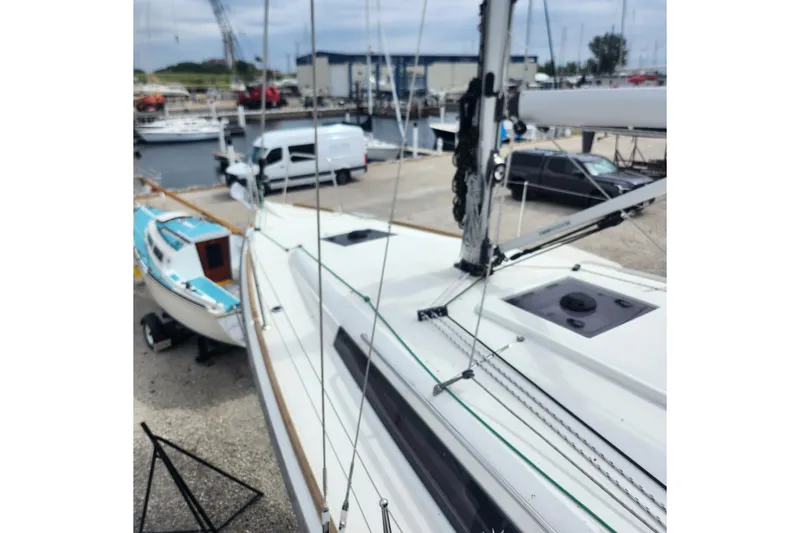 Slide: The Image of 2023 Jeanneau Sun Odyssey 349 sailboat docked at a marina, showcasing its sleek design. - 6