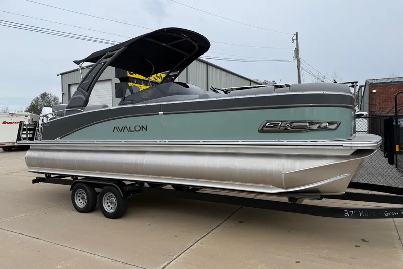 The Image of 2026 Avalon Catalina Quad Lounger Windshield pontoon boat on trailer, parked outdoors. - 0