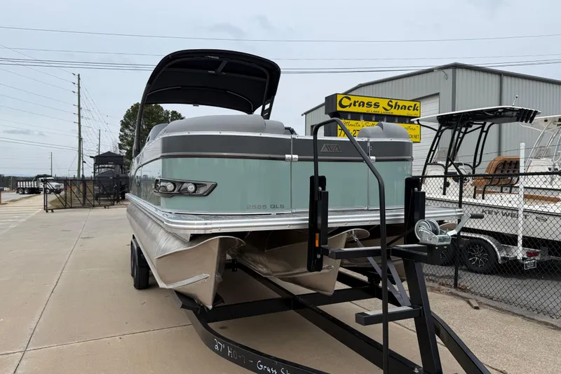 Slide: The Image of 2026 Avalon Catalina Quad Lounger Windshield boat on trailer at dealership. - 2