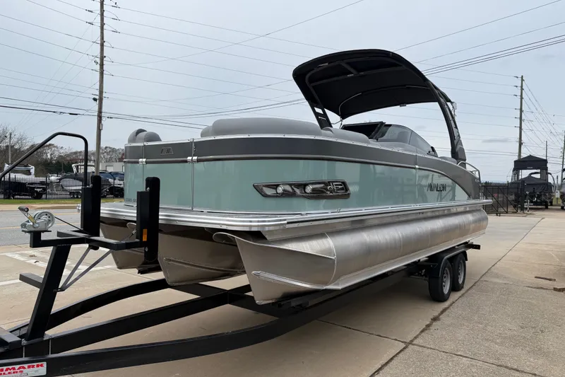Slide: The Image of 2026 Avalon Catalina Quad Lounger Windshield pontoon boat on trailer, parked outdoors. - 3