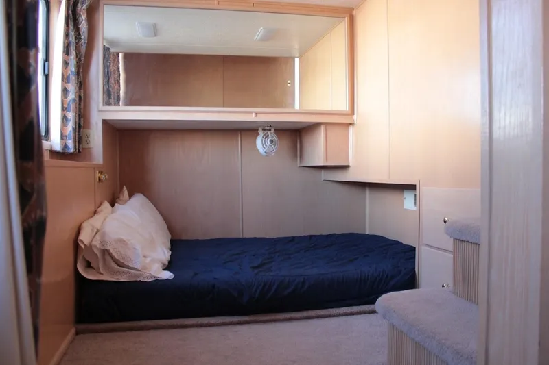 Slide: The Image of Cozy bedroom interior in 1996 Stardust Cruisers 1655 houseboat with bed and storage. - 15