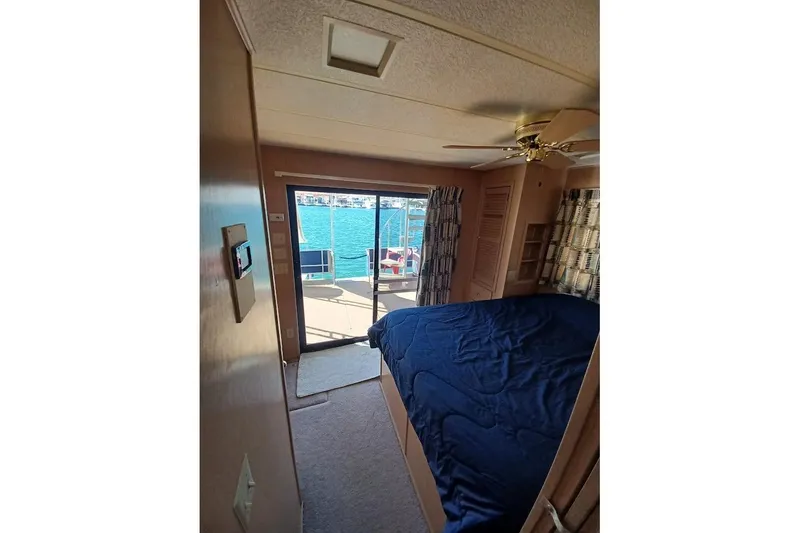 Slide: The Image of Interior of 1996 Stardust Cruisers 1655 with bed, ceiling fan, and lake view. - 16