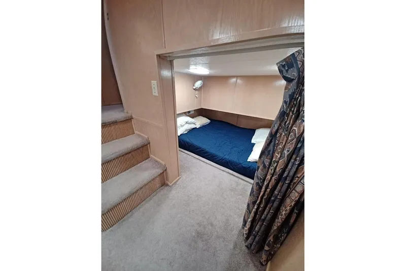 Slide: The Image of Cozy bedroom in 1996 Stardust Cruisers 1655 houseboat with blue bedding and patterned curtain. - 18