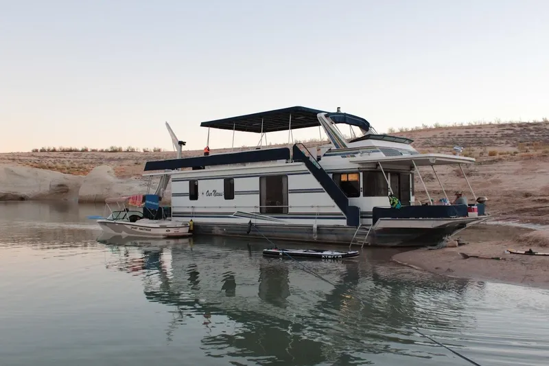 Slide: The Image of Houseboat on calm water, 1996 Stardust Cruisers 1655, docked near sandy shore. - 2