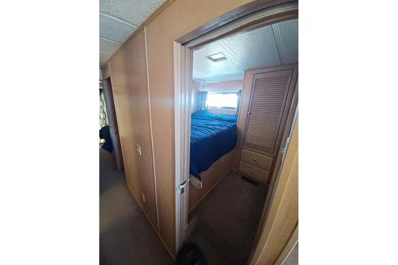Slide: The Image of Interior of 1996 Stardust Cruisers 1655, featuring a cozy bedroom with blue bedding. - 20