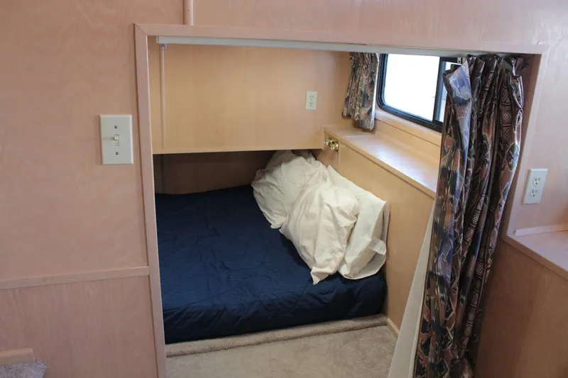 Slide: The Image of Cozy bedroom in 1996 Stardust Cruisers 1655 houseboat with blue bedding and patterned curtains. - 23