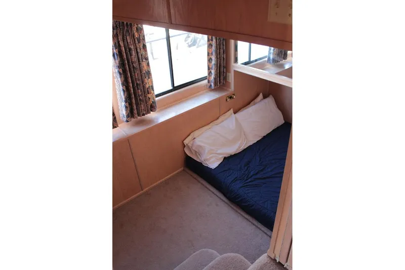 Slide: The Image of Interior of 1996 Stardust Cruisers 1655, featuring cozy bed and window with curtains. - 24