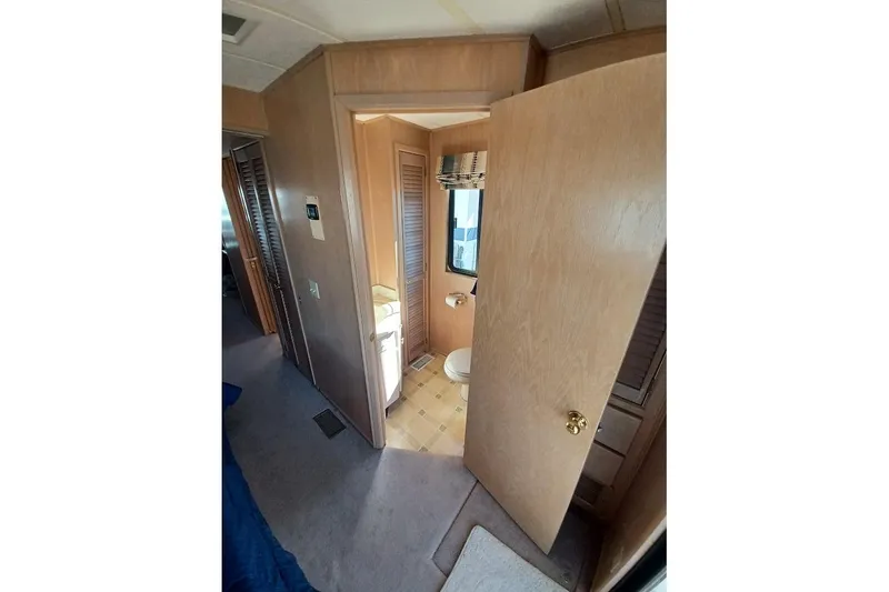 Slide: The Image of Interior of 1996 Stardust Cruisers 1655, featuring a compact bathroom with wooden door. - 25