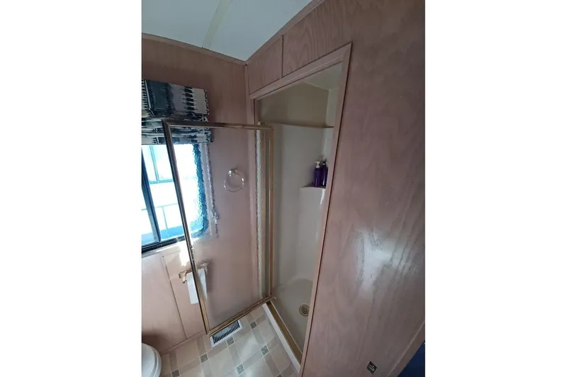 Slide: The Image of Shower area in 1996 Stardust Cruisers 1655 houseboat with glass door and wooden paneling. - 27
