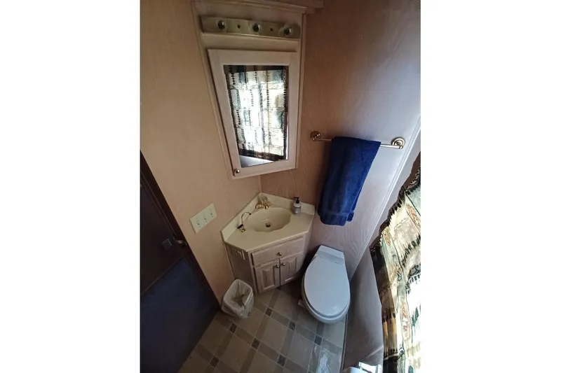 Slide: The Image of Bathroom interior of 1996 Stardust Cruisers 1655 with sink, toilet, and mirror. - 29