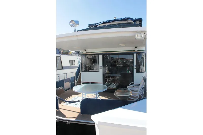 Slide: The Image of 1996 Stardust Cruisers 1655 houseboat with outdoor seating and table on deck. - 34