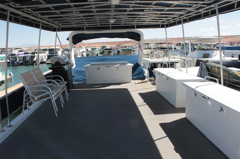 Slide: The Image of 1996 Stardust Cruisers 1655 houseboat deck with seating and storage, docked at marina. - 37