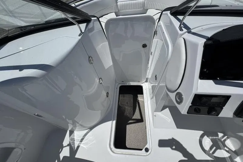 Slide: The Image of 2025 Stingray 231DC boat interior with open storage compartment and sleek design. - 10