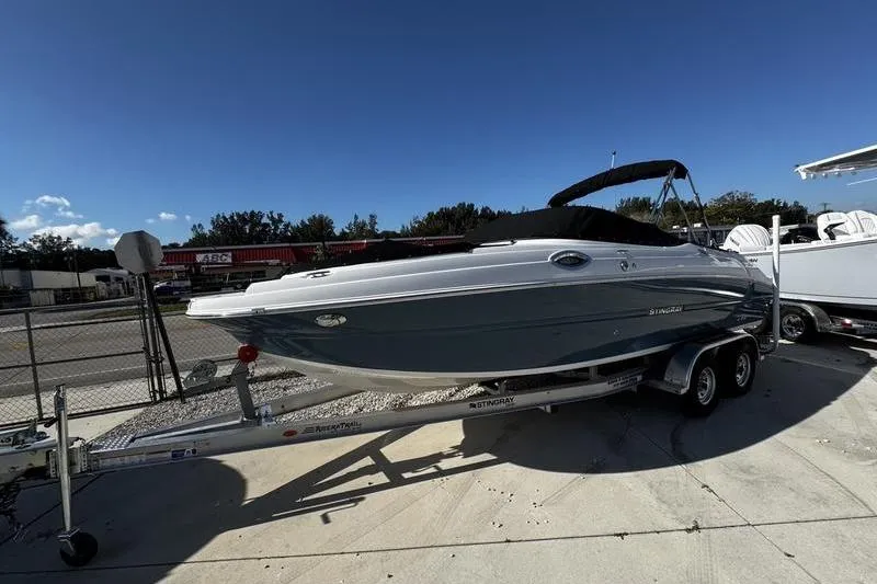Slide: The Image of 2025 Stingray 231DC boat on trailer under clear blue sky. - 3