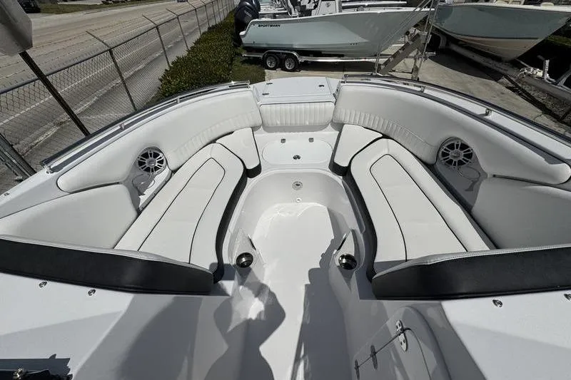 Slide: The Image of 2025 Stingray 231DC boat interior with white seating and speakers, docked outdoors. - 4