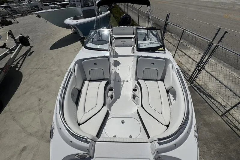 Slide: The Image of 2025 Stingray 231DC boat with spacious seating and sleek design, docked outdoors. - 5