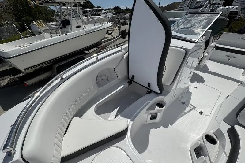 Slide: The Image of 2025 Stingray 231DC boat interior with white seating and open storage compartment. - 8