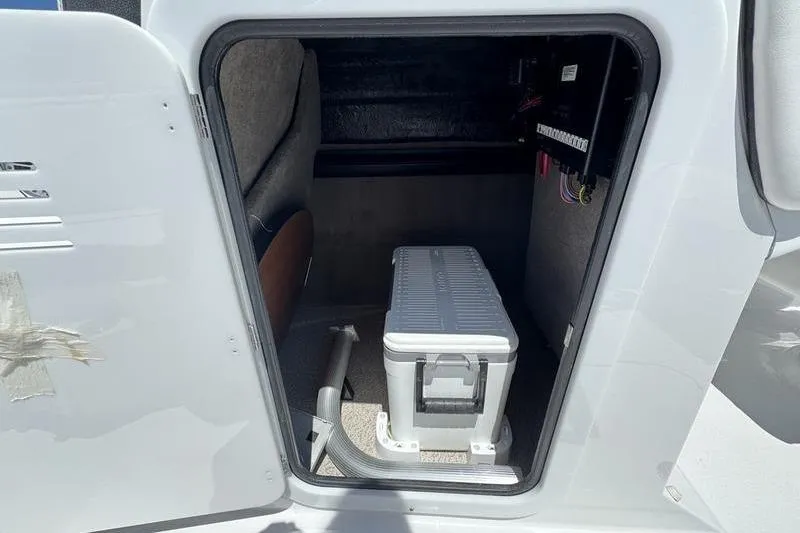Slide: The Image of Storage compartment of 2025 Stingray 231DC boat with cooler and wiring panel. - 9