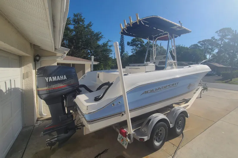Slide: The Image of 2003 Aquasport 205 Osprey boat with Yamaha outboard motor on a trailer. - 2