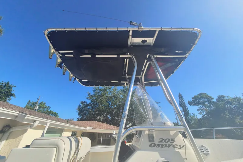Slide: The Image of 2003 Aquasport 205 Osprey boat with T-top under clear blue sky. - 3