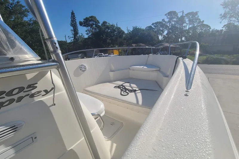 Slide: The Image of 2003 Aquasport 205 Osprey boat deck with seating and railing in sunny outdoor setting. - 7