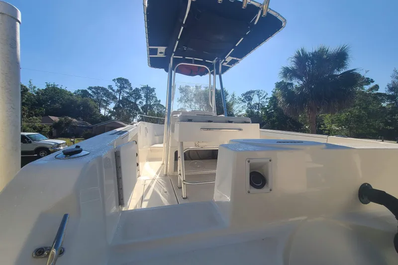 Slide: The Image of 2003 Aquasport 205 Osprey boat with T-top, parked outdoors under clear sky. - 8